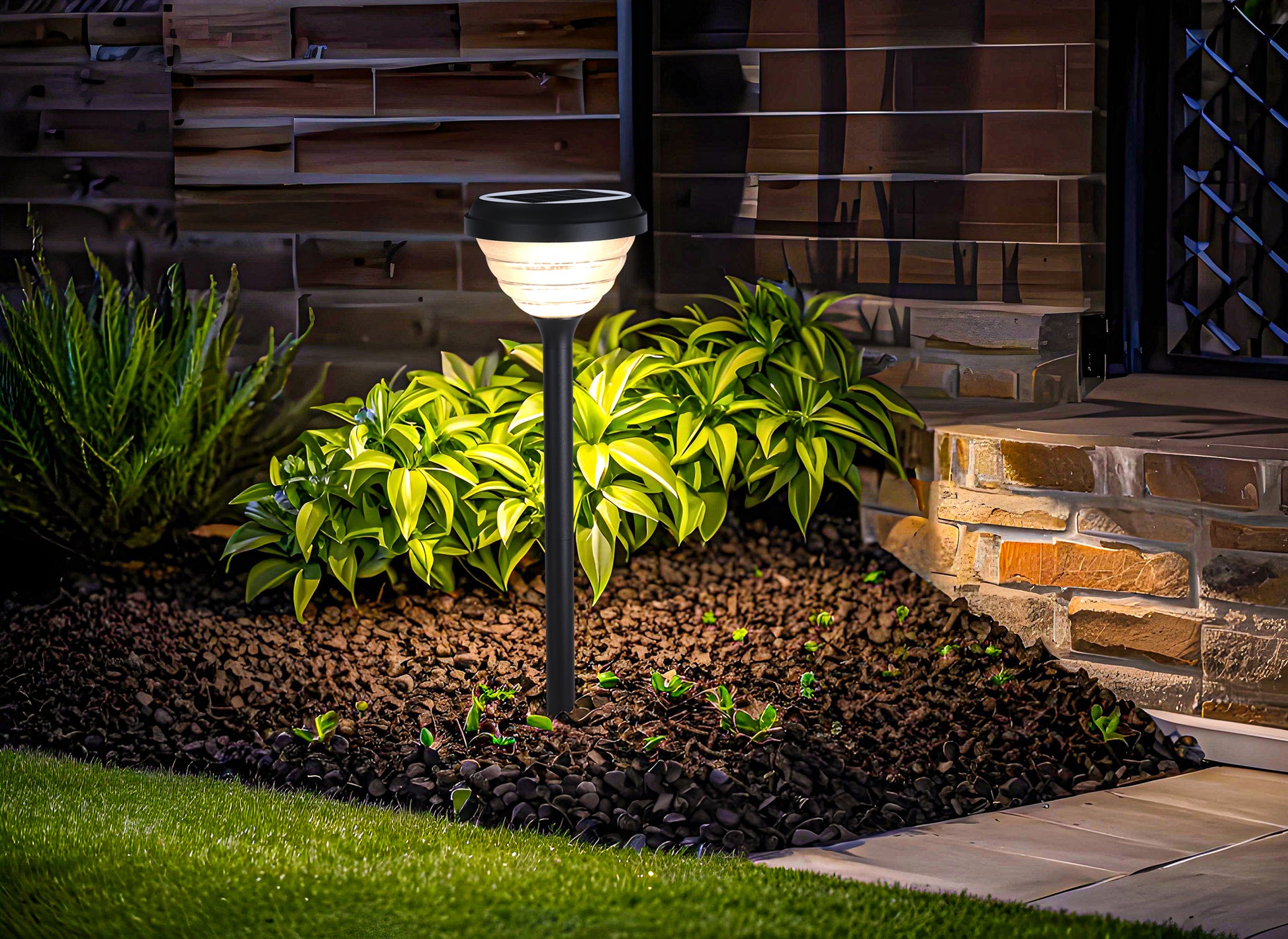 Little Conch Series Solar Lawn Light CPD1618 lighting a plant border beside a house entrance