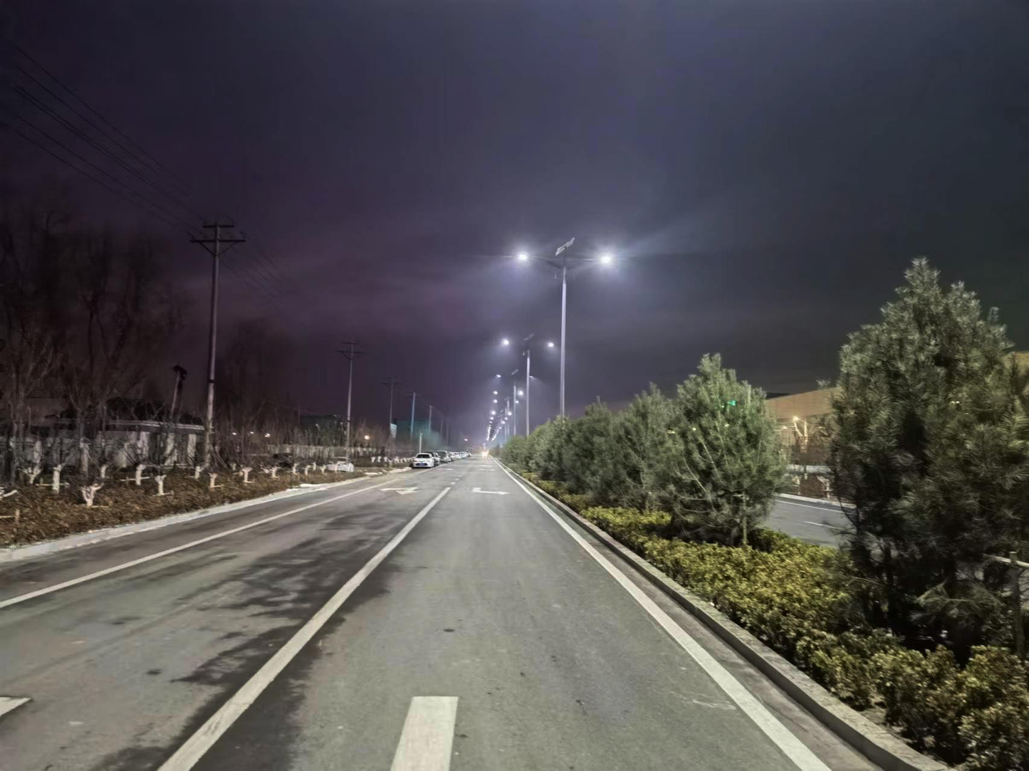 Neptune Series split solar street lights providing bright illumination on a wide road at night