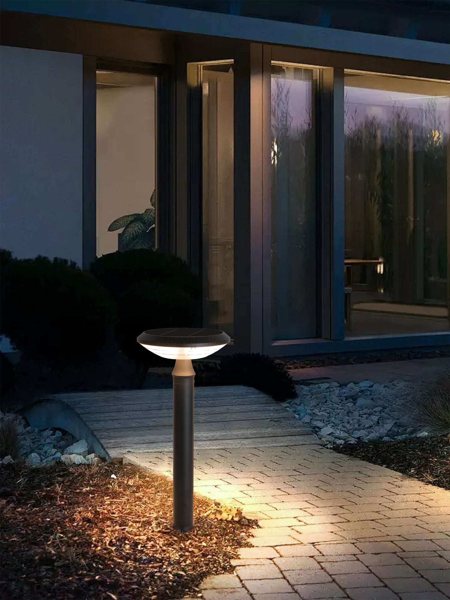 Round Moon Series Solar Lawn Light CPD3202 lighting a courtyard path beside a modern house