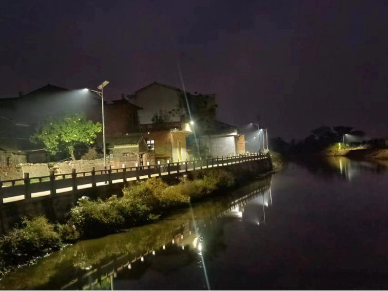 Super Crystal split solar street light installed along a riverside village road for night outdoor lighting